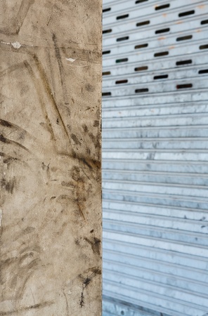 Close up grunge rectangular concrete column and steel shutter door in garage の写真素材