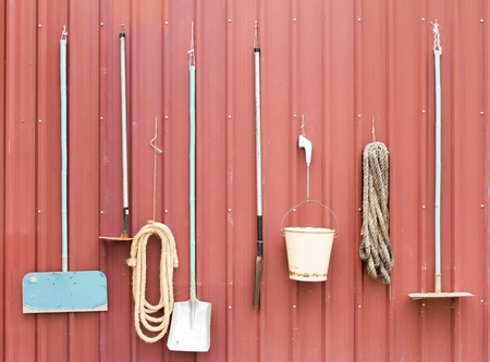 Farm tools hang on red barn wallの写真素材