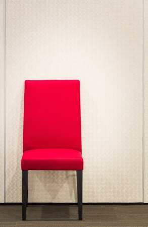 Red elegance chair on carpet floor near metal wallの写真素材