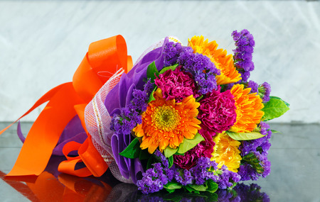 Close up gerbera and carnation flower bouquet on marble tableの写真素材