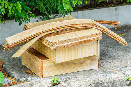 Close up old dirty and weathered broken particle board drawer on footpathの写真素材