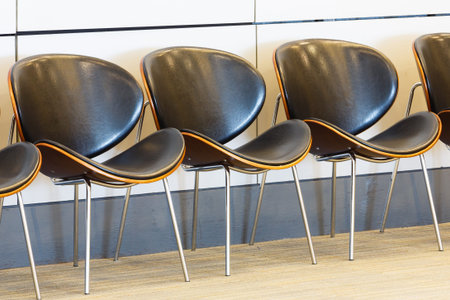 Close up row of waiting chairs and white color wall in office building