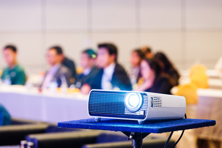 Close up projector in conference room with blurry people backgroundの写真素材