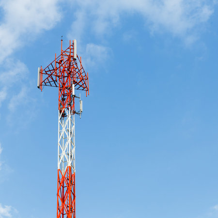 Close up red and white color antenna repeater tower on blue sky