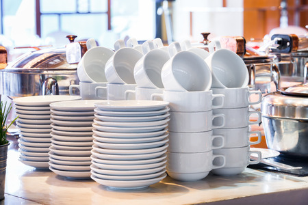 Close up stacks of white color ceramic coffee cup and dish ready for use in party room, catering serviceの写真素材