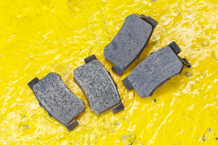 Close up old car disc brake pads on garage floor, automotive maintenance serviceの写真素材