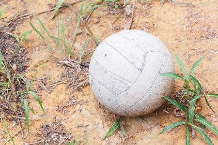Close up old and weathered leather soccer ball on dirty groundの写真素材