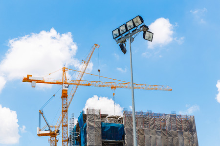 Floodlight tower on blue sky and white cloud in construction siteの写真素材