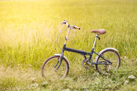 Folding bicycle in grass field, outdoor lifestyle, vintage conceptの写真素材