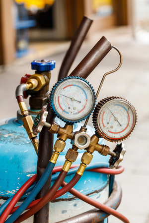 Close up refrigerant gas cylinder with manifold gaugeの写真素材