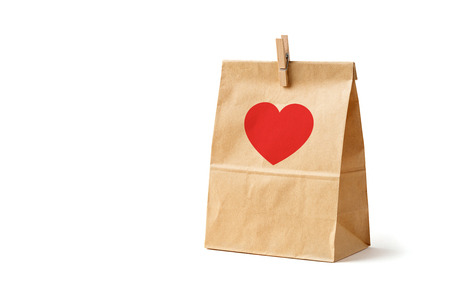 Brown color recycled paper bag with red heart isolated on white, recyclable paper bag for food, valentine love conceptの写真素材