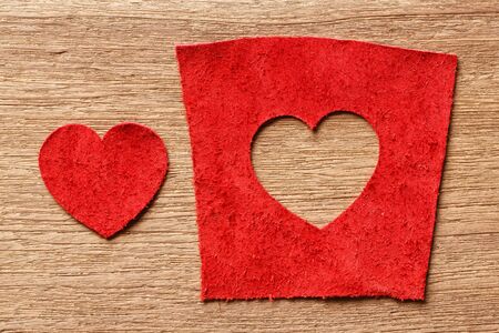 Heart shape red color genuine leather on wooden background, valentine and love 
conceptの写真素材