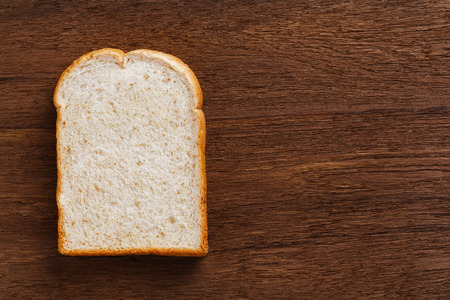 Sliced whole wheat bread on wooden cutting boardの写真素材