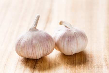 Close up organic garlic bulb on wooden chopping board, pungent and spicy flavor seasoning condimentの写真素材