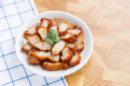 Deep fried golden color crispy pork belly with coriander leaf in ceramic dishの写真素材