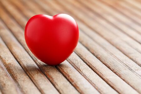 Close up red color heart shape ball on wooden table, valentine or love conceptの写真素材