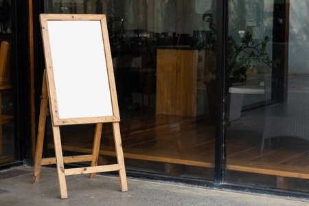 Old whiteboard stand in front of restaurant or cafe, empty for advertising displayの写真素材