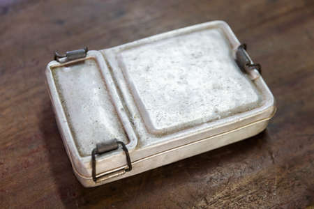 Closeup old and rusty aluminium lunch box on wooden table, old fashion vintage retro styleの写真素材