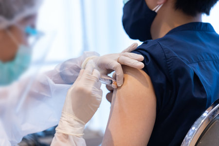Closeup covid-19 vaccine injecting into patient arm shoulder with single use plastic syringe by doctor, Boost the immune system with inactivated or adenovirus virusの写真素材