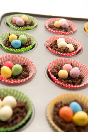 Chocolate Easter Nests in a baking tray ready to go in the oven with little eggs on topの写真素材