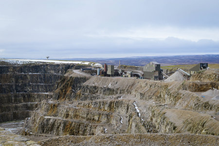 Snow covered Stone Quarry with the construction buildings and vehicles in the backgroundの写真素材