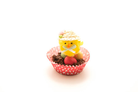 Chocolate Easter nest in a red spotty case with little easter eggs and a yellow chick on topの写真素材