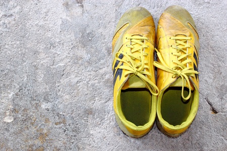 old yellow shoes on concreteの写真素材
