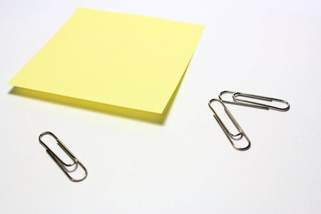 Yellow note with clip on white background