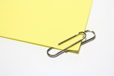 Yellow note with clip on white backgroundの写真素材