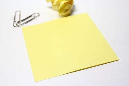 Yellow note with clip on white backgroundの写真素材