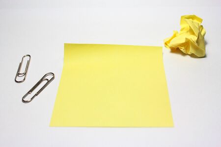 Yellow note with clip on white backgroundの写真素材