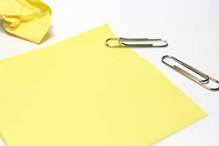 Yellow note with clip on white backgroundの写真素材