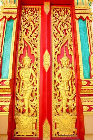 Native Thai style carving, painting on church door in the templeの写真素材