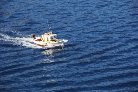 Small fishing boats go seawardの写真素材