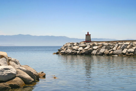 The red stone lighthouse at the harbor entranceの写真素材