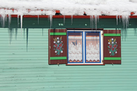 Wooden window farmhouse hand painted under the roof full of snowの写真素材