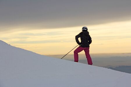 The silhouette of girls on skis on the mountainの写真素材