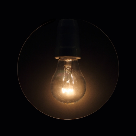 Glass light bulb glows in the darkの写真素材