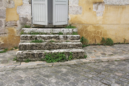 Old damaged stone staircase and old damaged wall