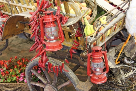 Old red lanterns apples and pumpkins on a wooden carriageの写真素材