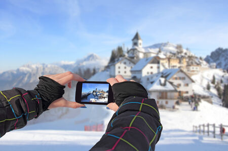 Photographing by cell phone of winter landscape in idyllic village Monte Lussari, Italyの写真素材