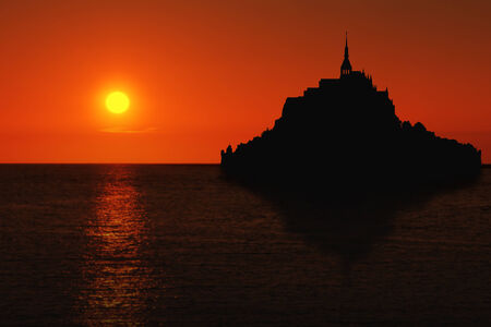 Le Mont Saint Michel silhouette with reflection in Normandy, France at sunsetの写真素材