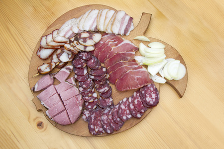 Delicious and tasty meat dishes  Ham, salami, prosciutto on a wooden wooden plate の写真素材