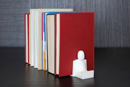 A pile of different books on a wooden shelfの写真素材