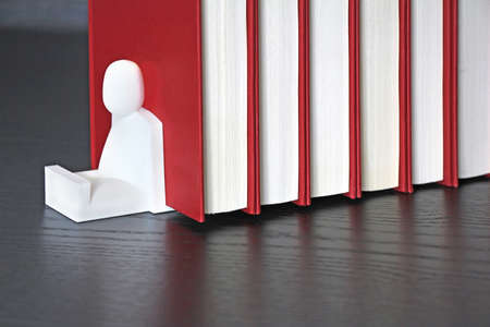 A pile of red books on a wooden shelfの写真素材
