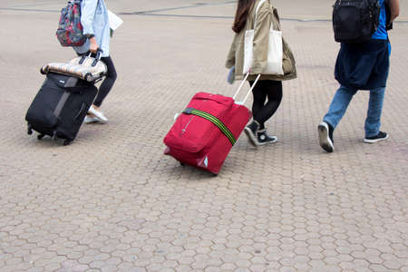 Young girls and man going on vacation with suitcaseの写真素材
