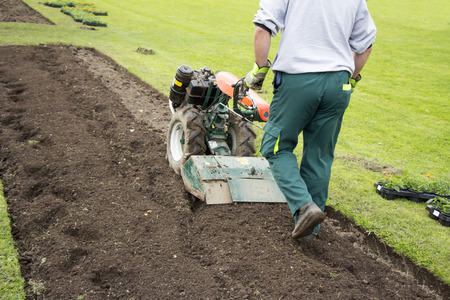 Man working in the garden with Garden Tiller の写真素材