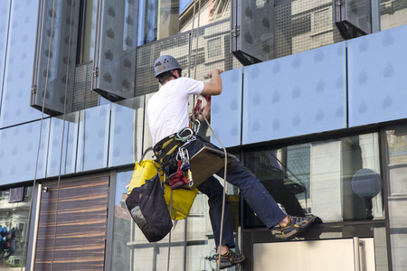 Climber wash windows and glass facade of the skyscraper の写真素材