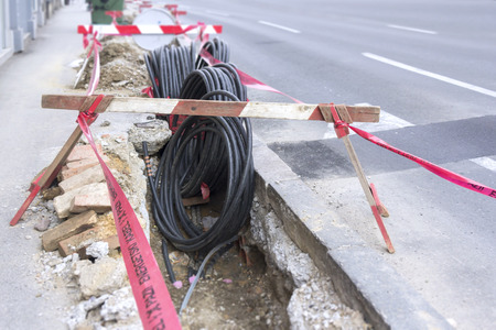 Road excavation at a construction site at conduits for the laying of fibre optic and electric cable の写真素材