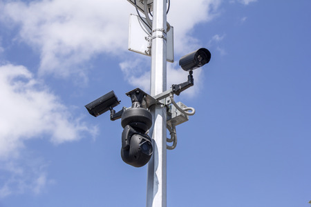 Three Security cameras on blue sky background の写真素材